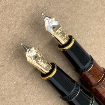 comparative sizes between old bicolor platinum izumo lacewood nib and new izumo urushi nib