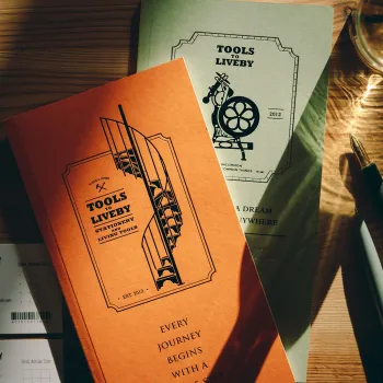 dos cuadernos tomoe river apoyados en una mesa de madera con la luz del sol entrando por la ventana