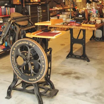 máquina de impresión tipográfica centenaria exhibida con orgullo en la entrada de la tienda de Taipei