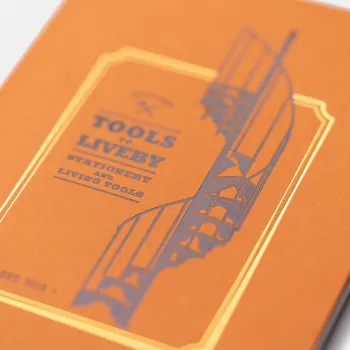 detalle de la portada naranja con relieve inspirada en la escalera de caracol de la tienda de kaohsiung