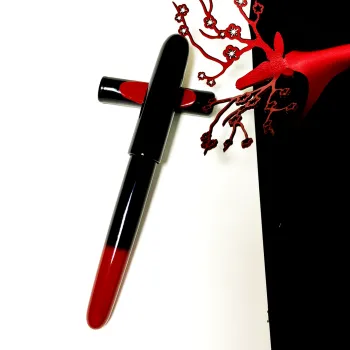 sailor urushi rei wajima akebono fountain pen next to a leather deer