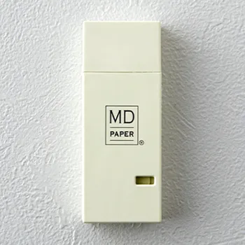 cinta correctora midori con tapa protectora y diseño minimalista sobre pared blanca con gotelé