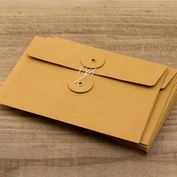 set of trc kraft orange envelopes size m arranged on wood surface